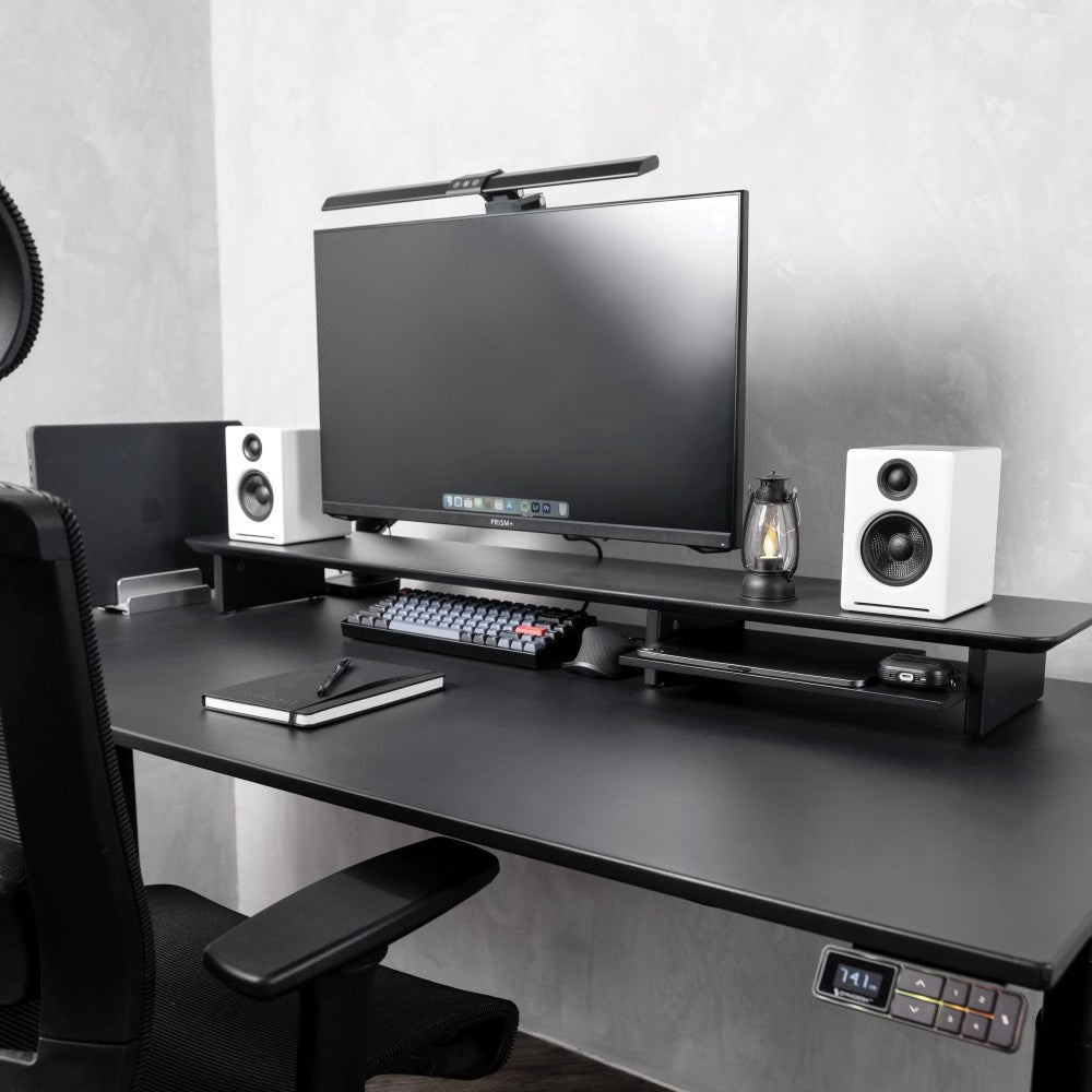 Omnidesk Arka black desk riser elevating monitor to eye level with clean cable-free workspace