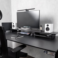 Omnidesk Arka black desk riser elevating monitor to eye level with clean cable-free workspace