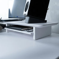 White monitor stand holding a laptop and computer monitor on a sit-stand desk