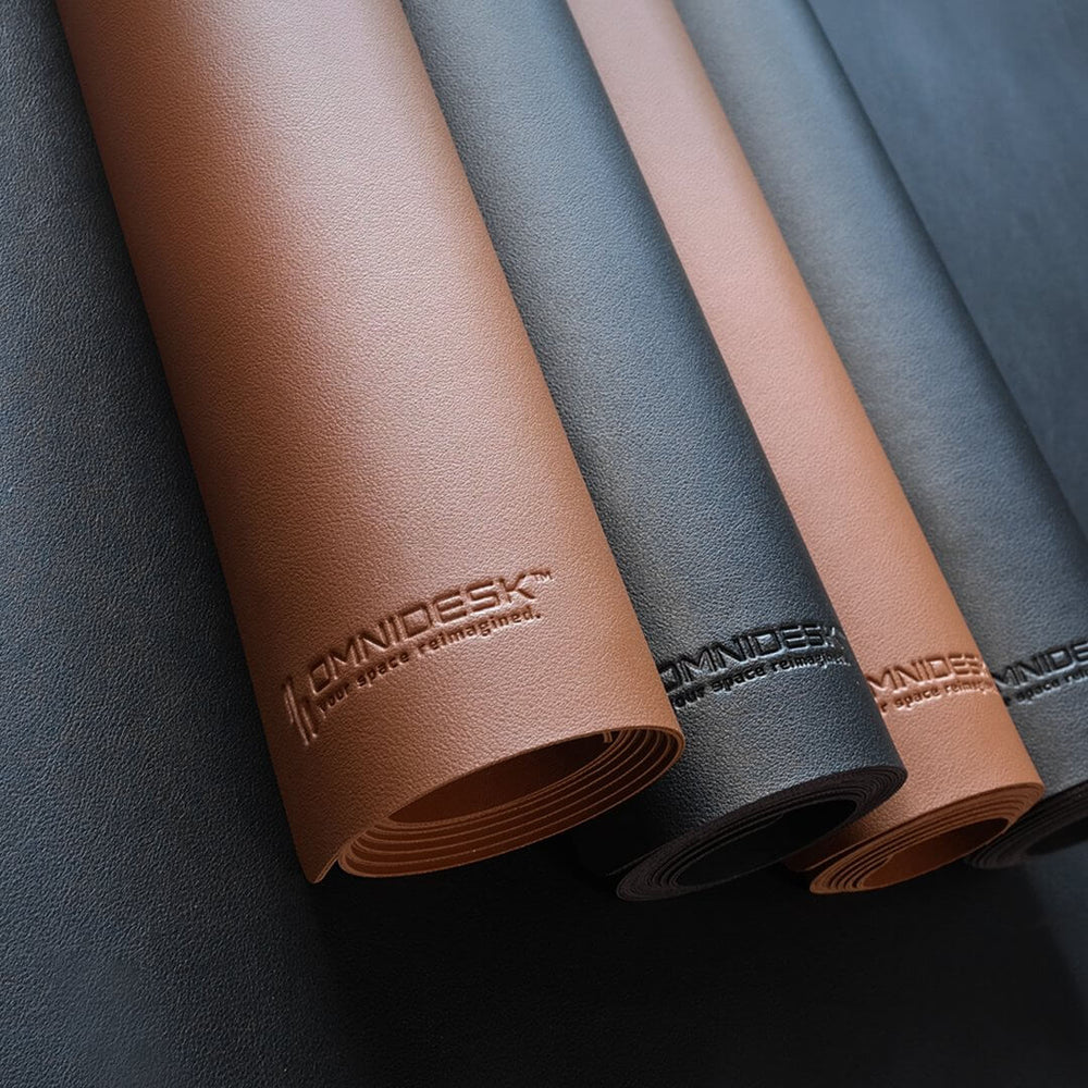 Omnidesk Titus Plus full sized premium desk mat in tan and onyx covering entire desktop workspace